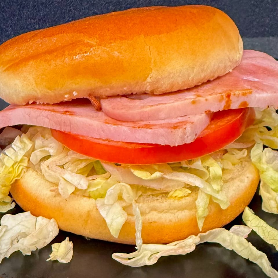 A Duke's Grill ham sandwich with lettuce and tomato on a golden bun.